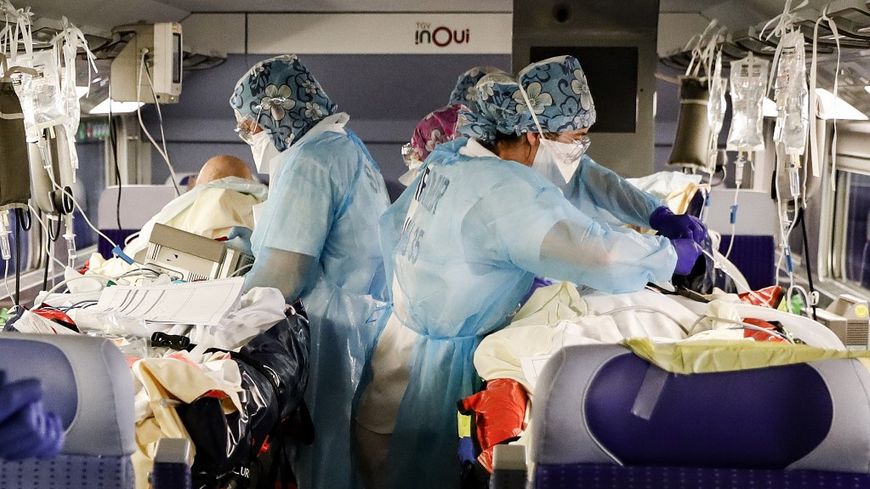 Le personnel médical installe des patients infectés par le Covid-19 à bord d'un train TGV médicalisé à la gare d'Austerlitz, à Paris, pour être évacué vers d'autres hôpitaux situés en Bretagne, le 1er avril 2020.
