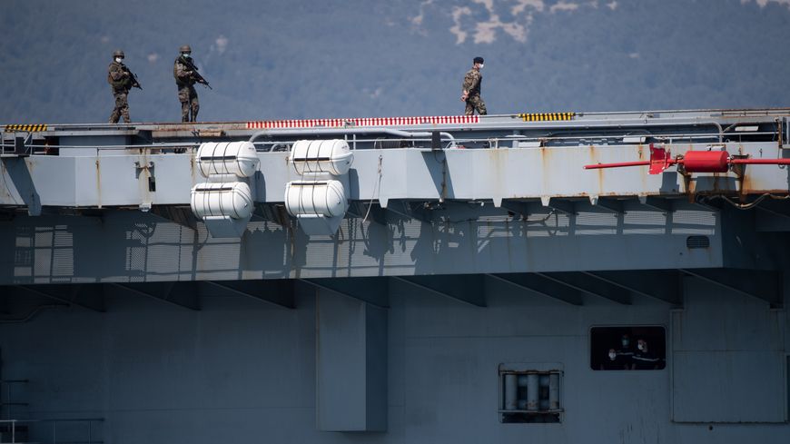 Des militaires masqués patrouillent sur le porte-avions Charles de Gaulle, le 12 avril 2020, à Toulon (Var).