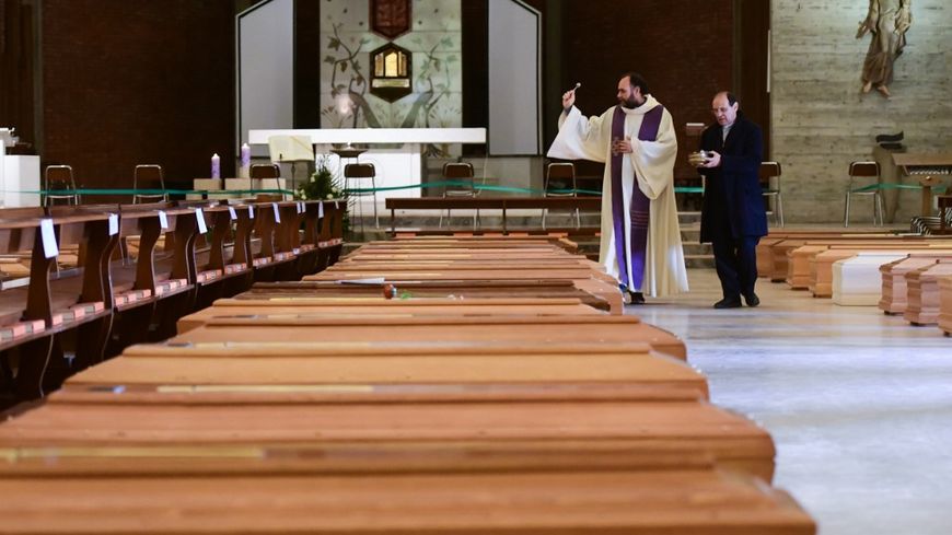 Le 28 mars 2020, le prêtre Don Marcello bénit les cercueils des personnes décédées du Covid-19, à l'intérieur de l'église de San Giuseppe à Seriate, dans la banlieue de Bergame en Italie.