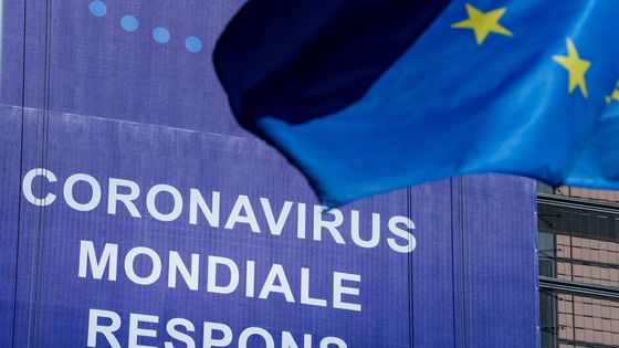 Un drapeau de l'Union européenne (UE) flotte devant une bannière sur laquelle on peut lire "Coronavirus Global Response" devant le bâtiment de la Commission européenne à Bruxelles, le 6 mai 2020 ©AFP - Kenzo TRIBOUILLARD / AFP