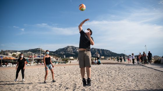 Des joueurs de volleyball masqués sur la plage du Prado à Marseille ©AFP - CLEMENT MAHOUDEAU