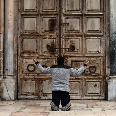 Un croyant chrétien devant une église fermée pour cause d'épidémie à Jérusalem le 09 avril 2020