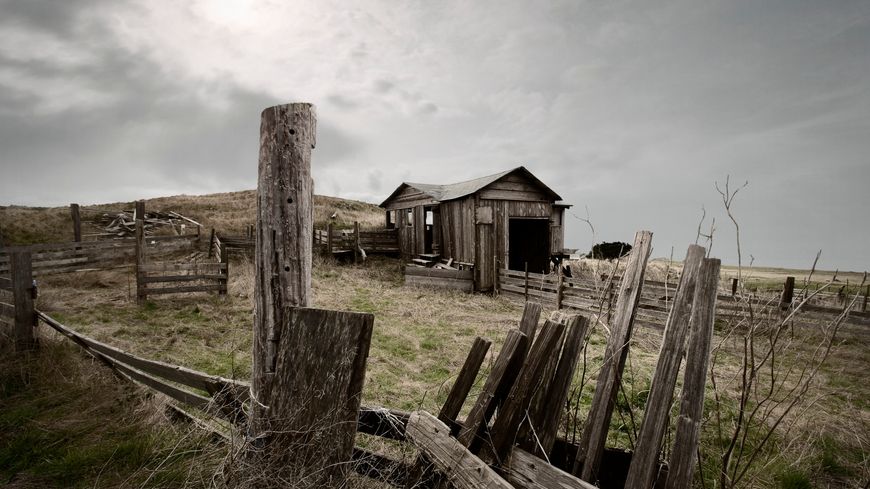 Une ferme isolée sous un ciel lourd