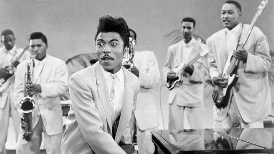 Musician Little Richard performs onstage with his band as his saxophone player Grady Gaines stands on the piano in circa 1957 in scene from the movie 'Mister Rock And Roll.' ©Getty - Michael Ochs Archives