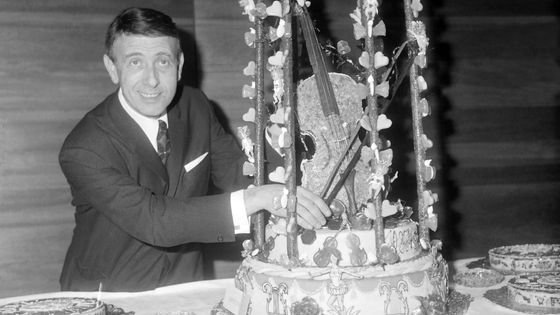 Franck Pourcel avec la pièce montée représentant un violon en cage, après avoir reçu son disque d'or le 6 février 1965 a Paris ©Getty - Keystone-France\Gamma-Rapho