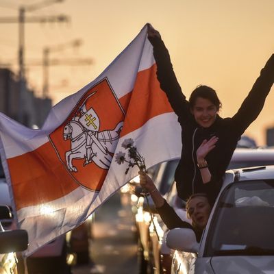 Des jeunes tiennent des fleurs et le drapeau de la Biélorussie. Ils protestent contre les violences policières récentes (Minsk- Biélorussie).