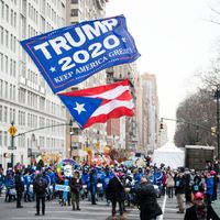 Un supporter de Donald Trump agite un drapeau pendant la marche des femmes à Manhattan (New york ,Etats-Unis), le 18 janvier 2020
