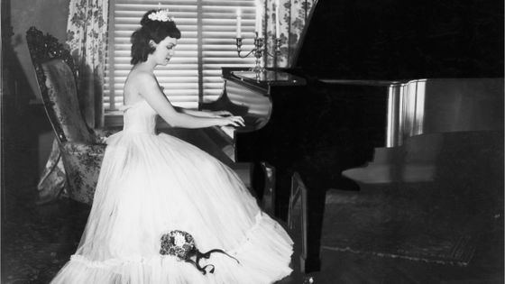 Femme en robe longue, jouant du piano ©Getty - FPG
