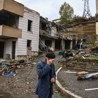 Un homme âgé passe devant des bâtiments détruits dans la principale ville séparatiste de la région du Haut-Karabakh, le 6 octobre 2020, alors que des combats sont en cours entre l'Arménie et l'Azerbaïdjan.
