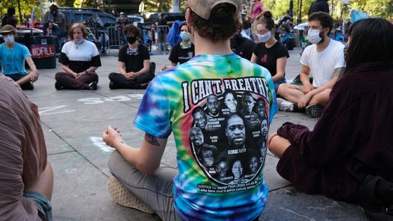 Un sympathisant du mouvement Black Lives Matter pratiquant le yoga lors d'une manifestation dans un parc à Manhattan, à New York, en juin 2020. ©AFP - SPENCER PLATT / GETTY IMAGES