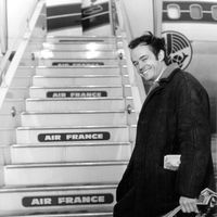 Le chef d'orchestre Jean-Claude Casadesus photographié devant un avion le conduisant à Montréal pour un concert (s. d.)
