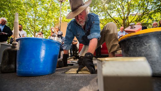 09 mai 2018, Gunter Demnig, sculpteur et créateur de l'idée du projet "Stolpersteine", place six pavés commémoratifs dans la Welschnonnengasse à Mayence, Allemagne. ©Getty