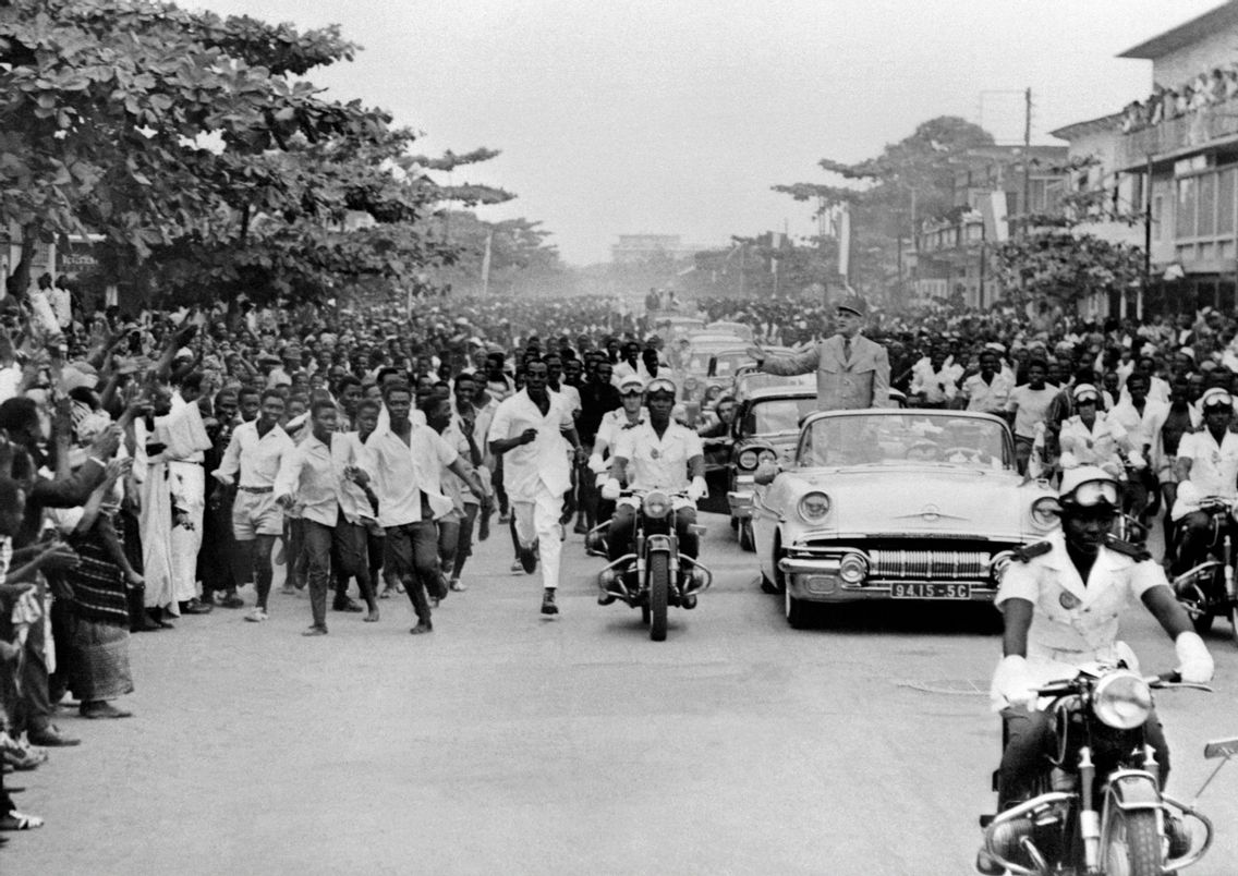 26 août 1958, Abidjan, le président français Charles de Gaulle, debout dans une voiture décapotable, salue la foule lors de sa visite officielle en Côte d'Ivoire, deux ans avant l'accession de la colonie à l'indépendance
