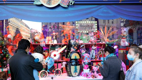 Passants observant les vitrines des grands magasins parisiens ©AFP - GEOFFROY VAN DER HASSELT