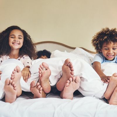 Deux enfants s'amusant dans le lit de leurs parents