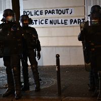 Collage du slogan "police partout, justice nulle part" durant les manifestations contre la loi de sécurité globale à Paris, décembre 2020