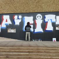 Un street-artiste écrit le mot Laïcité lors de l'inauguration de la place de la laïcité à Paris en décembre 2015