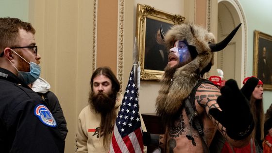 Des partisans du président américain Donald Trump, dont Jake Angeli (à droite), un partisan de QAnon connu pour son visage peint et son chapeau à cornes, manifestent au Capitole américain le 6 janvier 2021, à Washington, DC. ©AFP - SAUL LOEB