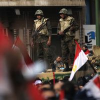Les soldats de l'armée égyptienne surveillent des manifestants anti-gouvernement se rassembler sur la place Tahrir, au Caire, le 11 février 2011