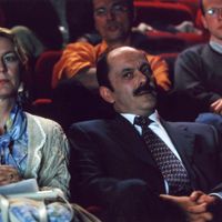 Aux côtés de sa femme (Christiane Millet), Castella (Jean-Pierre Bacri) assiste à une représentation de Bérénice.
