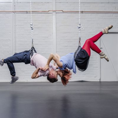 Modern aerialist dancers performing, hanging upside-down and kissing - Photos Sven Hagolani/ Getty