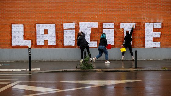 Des activistes placardent le mot laicité, à Montreuil (93), octobre 2020 ©AFP