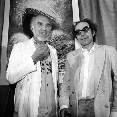 Le cinéaste Jean-Luc Godard est accompagné de l'acteur français Michel Piccoli pour la présentation de son nouveau film "Passion" lors du Festival de Cannes, le 24 mai 1982.