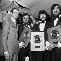 12 juillet 1969, Antibes, le groupe grec Aphrodite's Child, formé par Demis Roussos (2eL), Loukas Sideras (2eR) et Vangelis (R) récompensé par le PDG de Phonogram Louis Hazan (L) du prix du disque d'or