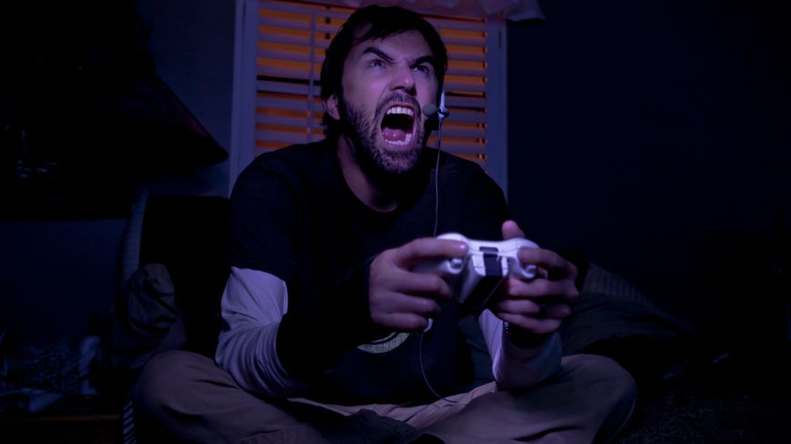 Un homme s'énerve en jouant aux jeux vidéos - (Romona Robbins)