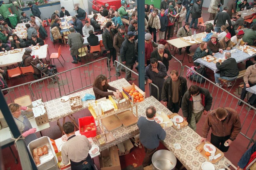 Des bénévoles des Restos du Cœur distribuent des repas à des personnes en difficulté, le 16 décembre 1996 dans un centre du 19e arrondissement de Paris, au premier jour de la 12e action consécutive de l'association fondée par Coluche