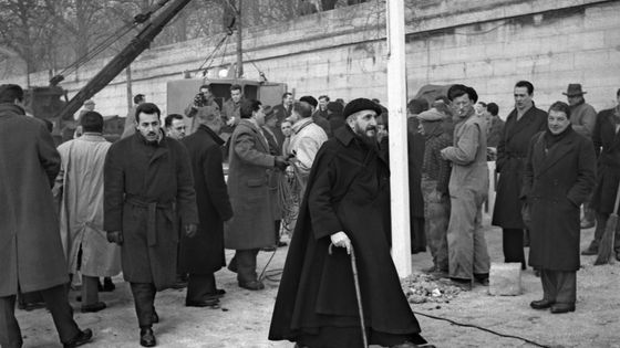 L'abbé Pierre alors que les nouvelles maisons construites par l'architecte Jean Prouvé en quatre jours pour les sans-abris sont en train d’être installées, le 20 février 1956. ©AFP - afp