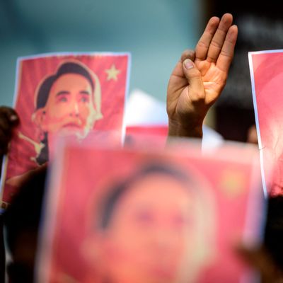 Des manifestants brandissent des photographies d'Aung San Suu Kyi, détenue, lors d'une manifestation contre le coup d'État militaire birman, devant l'ambassade du Myanmar à Bangkok, le 8 février 2021.