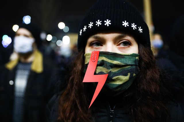 Wielu protestujących pokazywało znaki i nosiło maski ozdobione czerwonymi błyskawicami jako znak aktywistów proaborcyjnych.