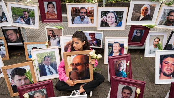 4 juin 2020 à Coblence, en Allemagne occidentale, la militante syrienne Wafa Mustafa tient une photo de son père lors d'une manifestation en marge du procès de Coblence ©AFP - THOMAS LOHNES