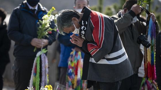 Un homme prie devant la mer à Hisanohama, dans la préfecture de Fukushima, lors du dixième anniversaire de la catastrophe nucléaire. ©AFP - CHARLY TRIBALLEAU
