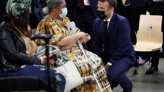Le Président Emmanuel Macron s'adressant à une patiente au centre de vaccination de Bobiny ©AFP - Benoît Tessier