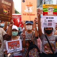 Des manifestants pro-démocratie thaïlandais brandissant des pancartes relatives à l'"Alliance du thé au lait" et à la situation au Myanmar, Bangkok, 28 février 2021