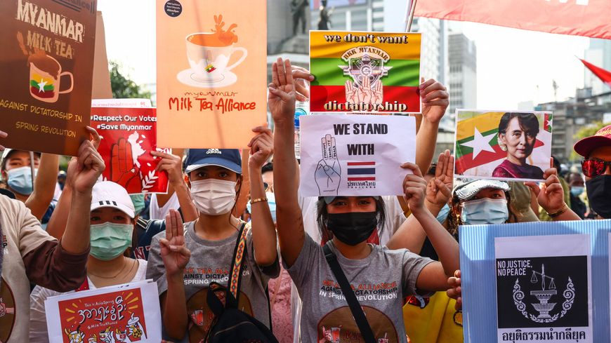 Des manifestants pro-démocratie thaïlandais brandissant des pancartes relatives à l'"Alliance du thé au lait" et à la situation au Myanmar, Bangkok, 28 février 2021