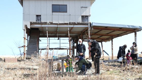 11 mars 2021 : Ichiro Shiga prie sur le site de sa maison à Futaba, dans la préfecture de Fukushima, où s'est notamment rendue notre journaliste. L'épouse d'Ichiro Shiga - Sachiko - et sa petite-fille Hitomi sont toujours portées disparues. ©AFP - Kaname Muto / Yomiuri / The Yomiuri Shimbun