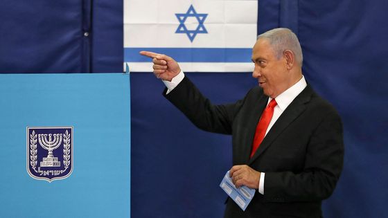 Le Premier ministre israélien Benjamin Netanyahu fait des gestes en votant dans un bureau de vote à Jérusalem le 23 mars 2021 lors de la quatrième élection nationale en deux ans. ©AFP - RONEN ZVULUN