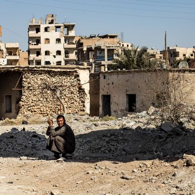 Un homme est assis accroupi au milieu des décombres de bâtiments détruits dans la ville de Raqa, dans le centre-est de la Syrie, le 26 février 2021.