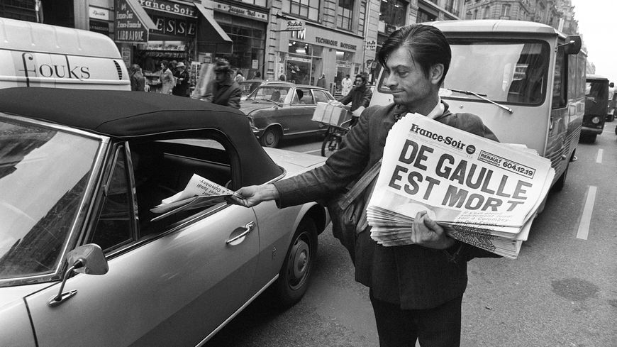 Un vendeur de rue propose à un automobiliste France-Soir annonçant la mort du général Charles de Gaulle, le 10 novembre 1970, rue Réaumur à Paris (devant le siège du journal).