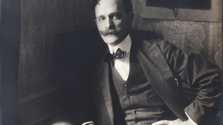 Marius de Zayas photographié devant l'une de ses caricatures par Paul Burty Haviland, vers 1913.