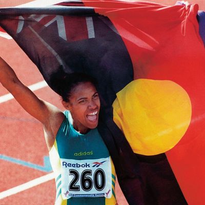 Cathy Freeman, athlète australienne spécialiste du 400 mètres, championne olympique et double championne du monde de la discipline célèbre sa victoire et son héritage culturel en agitant les drapeaux australiens et aborigènes en 2006.