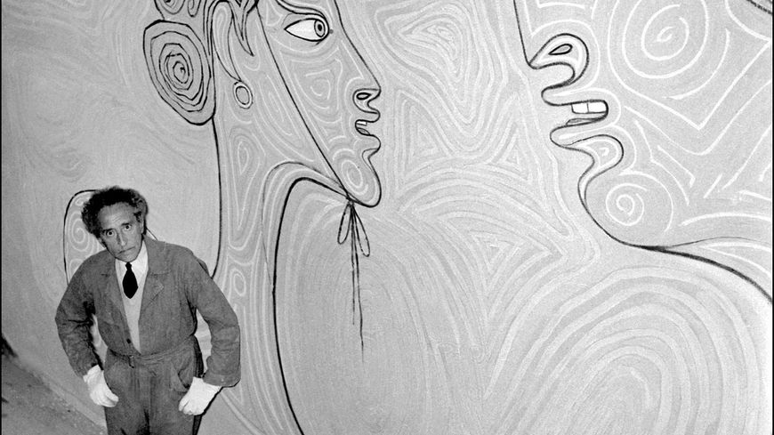 Photo prise le 27 Septembre 1957 de l'écrivain, poète, cinéaste, peintre et dessinateur Jean Cocteau, posant devant la fresque qu'il a peinte à l'intérieur de la salle de mariage de Menton.