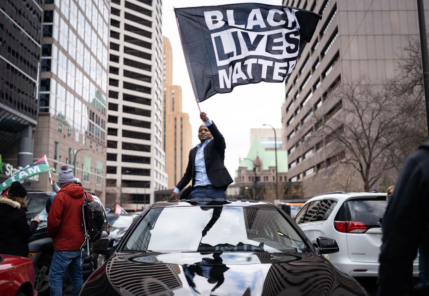Un homme brandit un drapeau du mouvement contre le racisme et les violences policières, devant le palais de justice de Minneapolis.