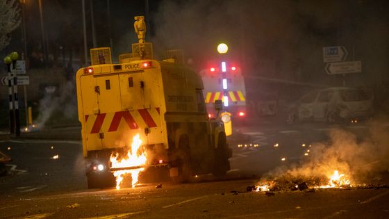 Flammes à l'arrière d'un véhicule de police après que des violences ont éclaté à Newtownabbey, au nord de Belfast, en Irlande du Nord, le 3 avril 2021. ©AFP - PAUL FAITH