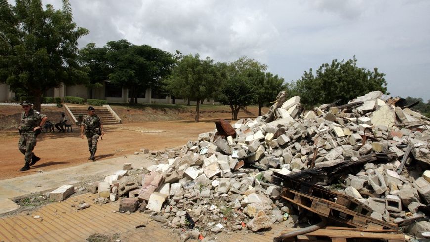 Deux soldats français devant un bâtiment détruit par le bombardement de 2004 à Bouaké