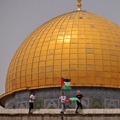 Des fidèles musulmans palestiniens brandissent leur drapeau national lors d'affrontements avec les forces de sécurité israéliennes dans l'enceinte de la mosquée Al-Aqsa à Jérusalem, le 21 mai 2021.