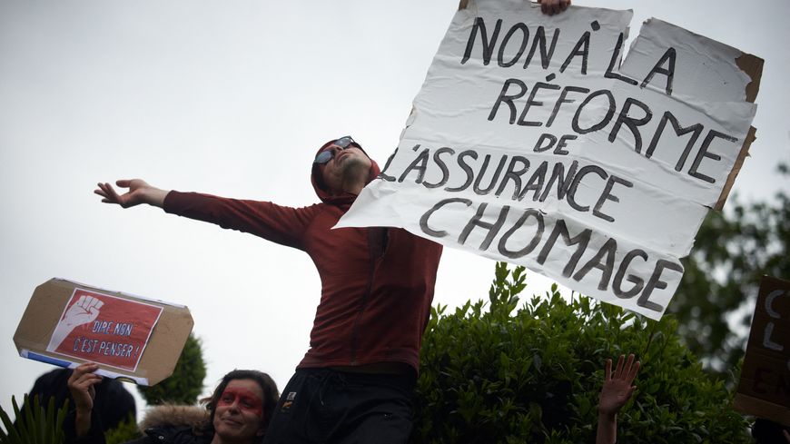Un manifestant brandit une pancarte contre la réforme de l’assurance chômage pour la fête du Travail, le 1er mai 2021 à Toulouse.